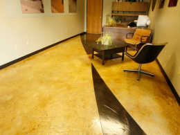 Hand-textured concrete with a stain, accent color, and seal in a Las Vegas commercial space.
