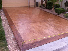 Image of stamped concrete driveway with dark and light red stain details.