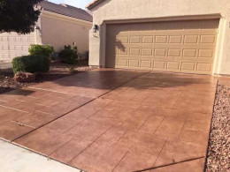 Image of a random-stone overlay concrete driveway with a terracotta-colored stain.