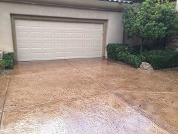 Image of terracotta stained and stamped concrete driveway.