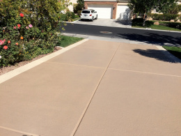 Image of a concrete driveway with a sand-colored spray texture coating.