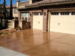 Image of a light brown stain and resealed concrete driveway.