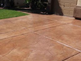 Image of a thin-cut flagstone overlay concrete driveway with a reddish-brown stain.