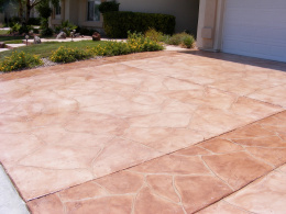 Image of a wide-cut flagstone overlay with terracotta stain on a concrete driveway.