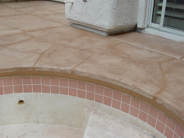 Closeup image of a wide-cut flagstone overlay on the edge of a pool deck.