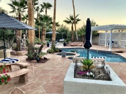 Image of a backyard paradise with a flagstone overlay concrete pool deck and patio.