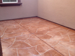 Image of a reddish-stained, wide-cut flagstone overlay concrete courtyard.