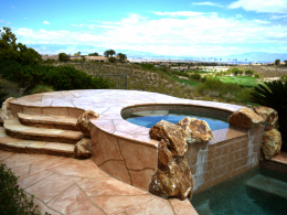 Image of a home spa with a wide-cut flagstone overlay concrete pool deck.