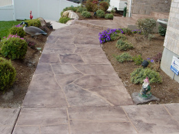 Image of a wide-cut flagstone overlay concrete walkway with cool-brown and gray stains.