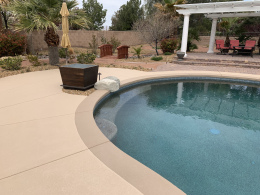 Closeup of concrete texturing of a Las Vegas pool deck with highlight, border color, and paver patio.