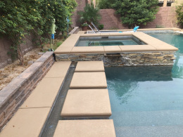 Textured concrete pool deck and stepping stones at a Las Vegas home.