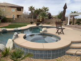 Closeup of a concrete textured spa and pool deck with rock features in Las Vegas.