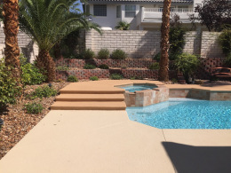 Textured concrete pool deck with accent color on stairs and around spa in Las Vegas.