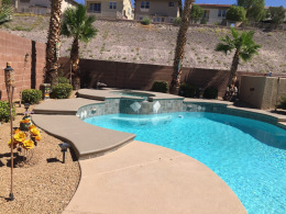 Textured concrete pool deck with accent color and tilework around spa in Las Vegas.
